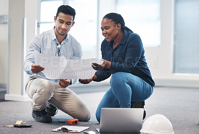 Buy stock photo Shot of a young architect talking to an interior designer while looking at a floor plan for the office
