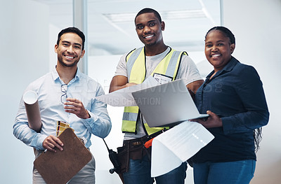 Buy stock photo Shot of a group of architects standing together and holding floor plans in a room before renovation