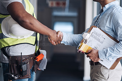 Buy stock photo Cropped shot of two unrecognizable architects standing together and shaking hands after a discussion about the room before they renovate