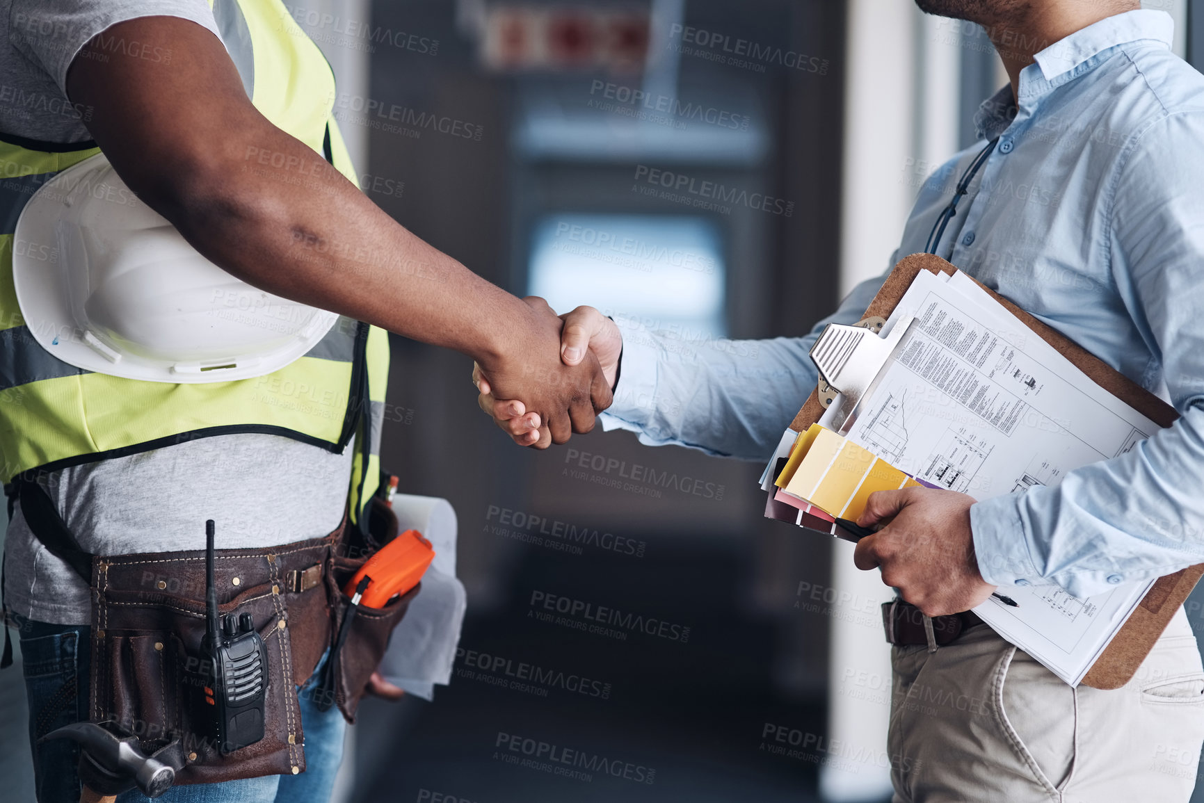 Buy stock photo Cropped shot of two unrecognizable architects standing together and shaking hands after a discussion about the room before they renovate