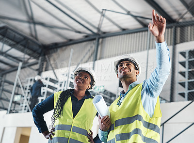 Buy stock photo Shot of two young contractors standing together in the warehouse and observing the layout