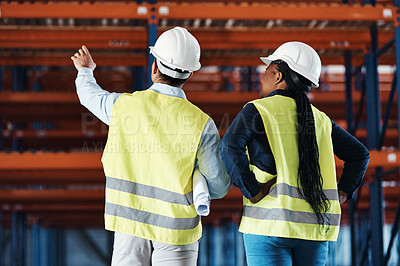 Buy stock photo Shot of two unrecognizable contractors standing together in the warehouse and observing the layout
