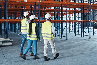 Buy stock photo Shot of a group of contractors walking through the warehouse together
