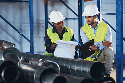 Buy stock photo Shot of two young contractors crouched down in the warehouse during a stock-take
