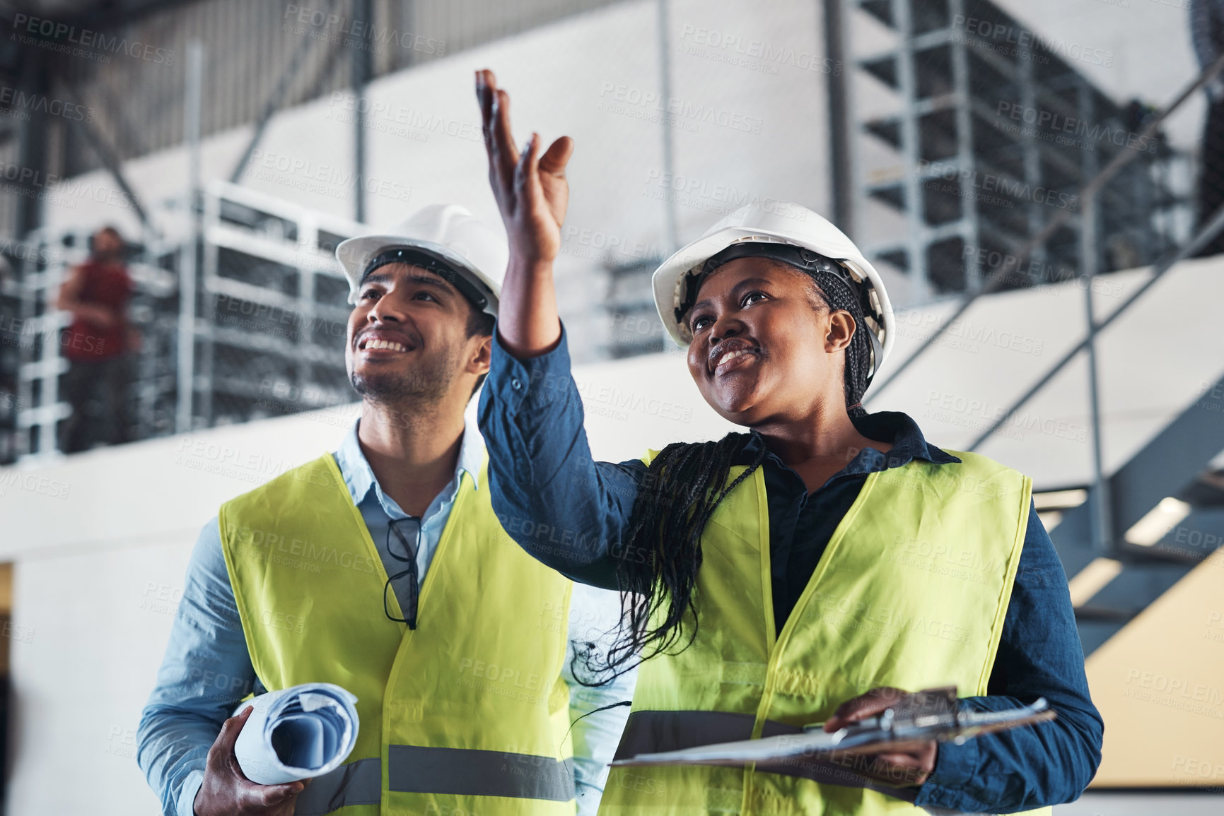 Buy stock photo Shot of two young contractors standing together in the warehouse and observing the layout