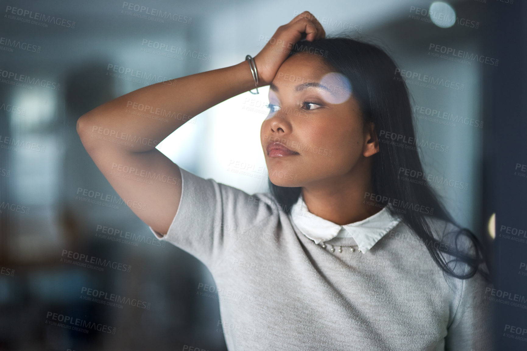 Buy stock photo Shot of a young businesswoman looking out the window in an office