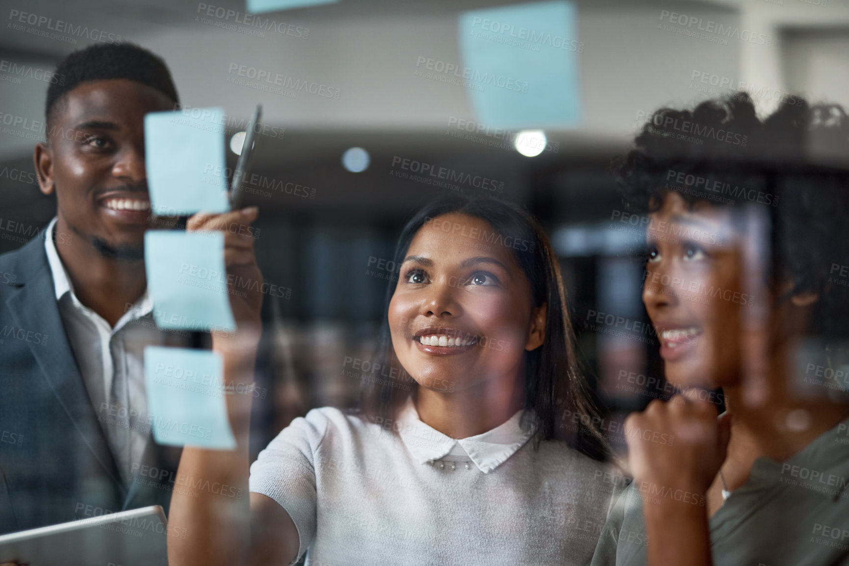 Buy stock photo Shot of three businesspeople working in a modern office