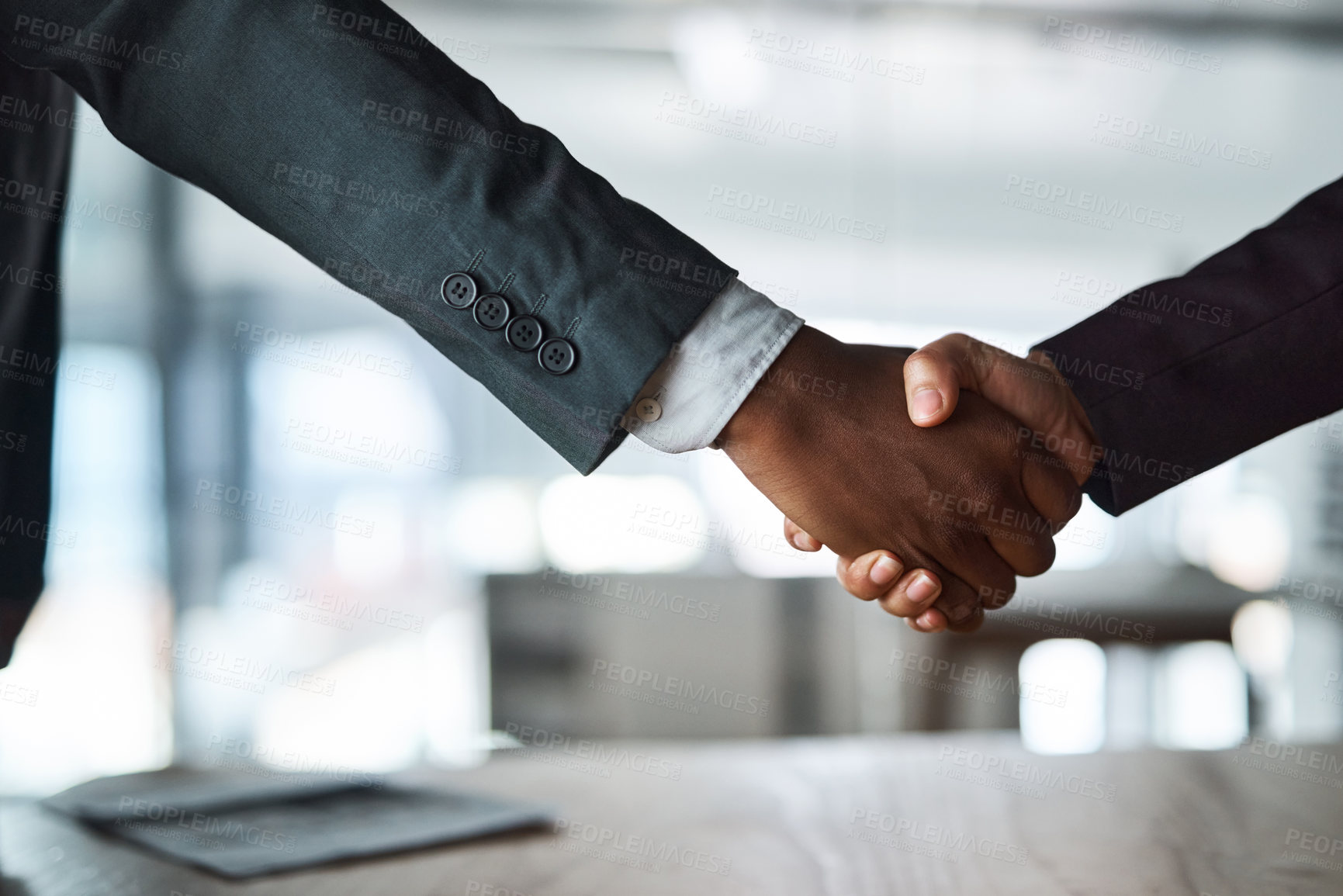 Buy stock photo Cropped shot of two unrecognizable businesspeople shaking hands in an office