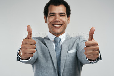 Buy stock photo Studio shot of a confident businessman showing thumbs up while standing against a grey background