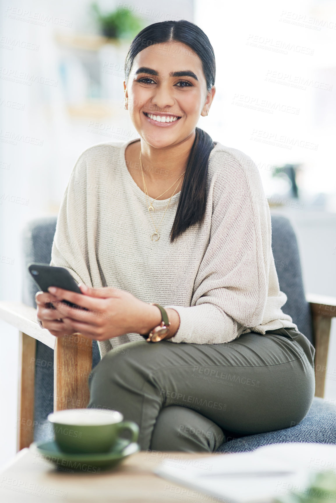 Buy stock photo Portrait of a young businesswoman using a cellphone in an office