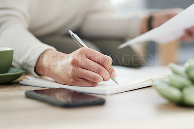 Buy stock photo Closeup shot of an unrecognisable businesswoman writing notes while going through paperwork in an office