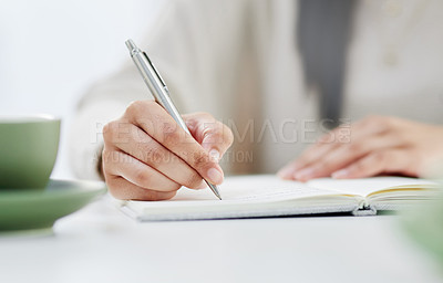 Buy stock photo Closeup shot of an unrecognisable businesswoman writing in a notebook in an office