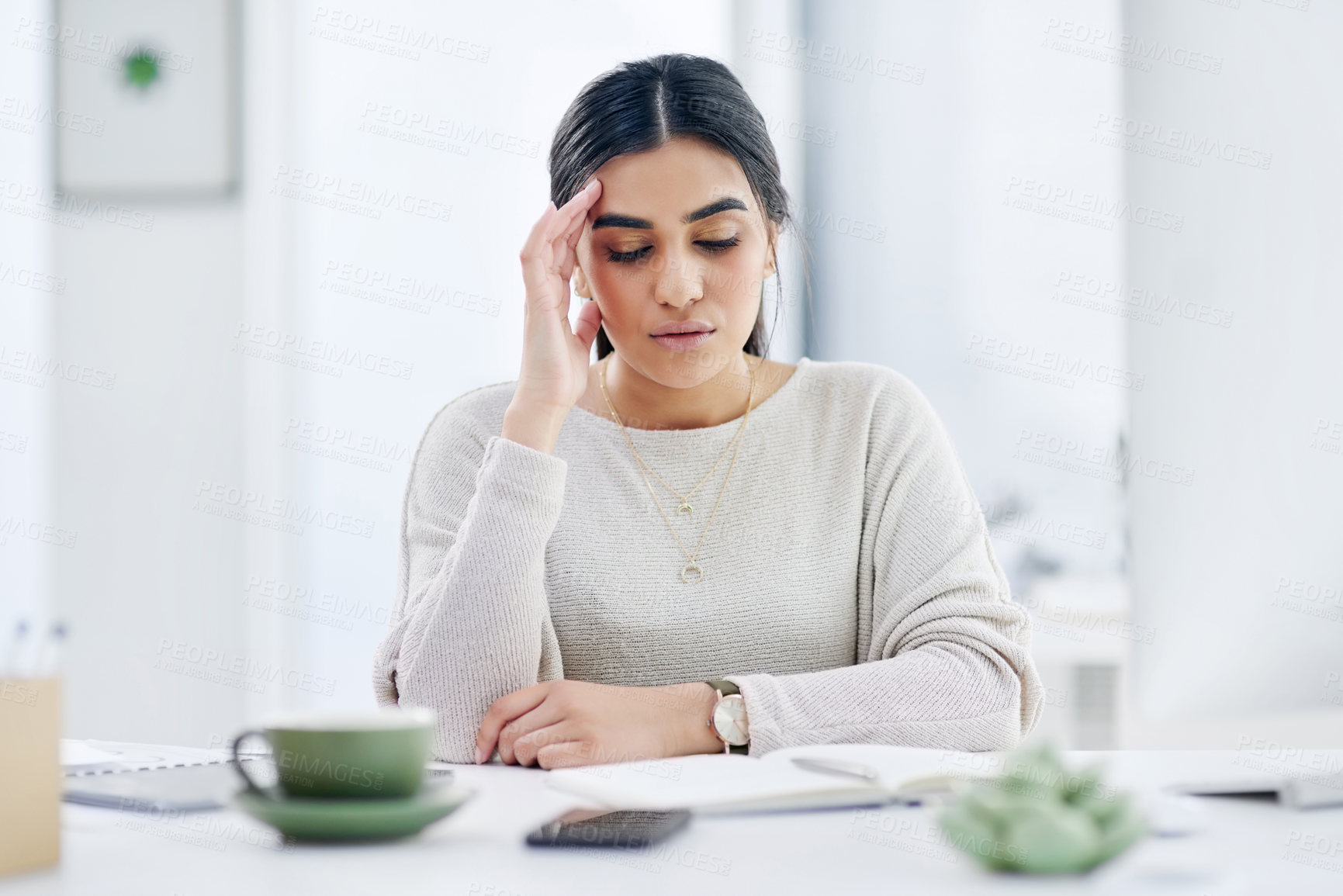 Buy stock photo Shot of a young businesswoman looking stressed out while working in an office