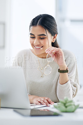 Buy stock photo Shot of a young businesswoman working on a laptop in an office
