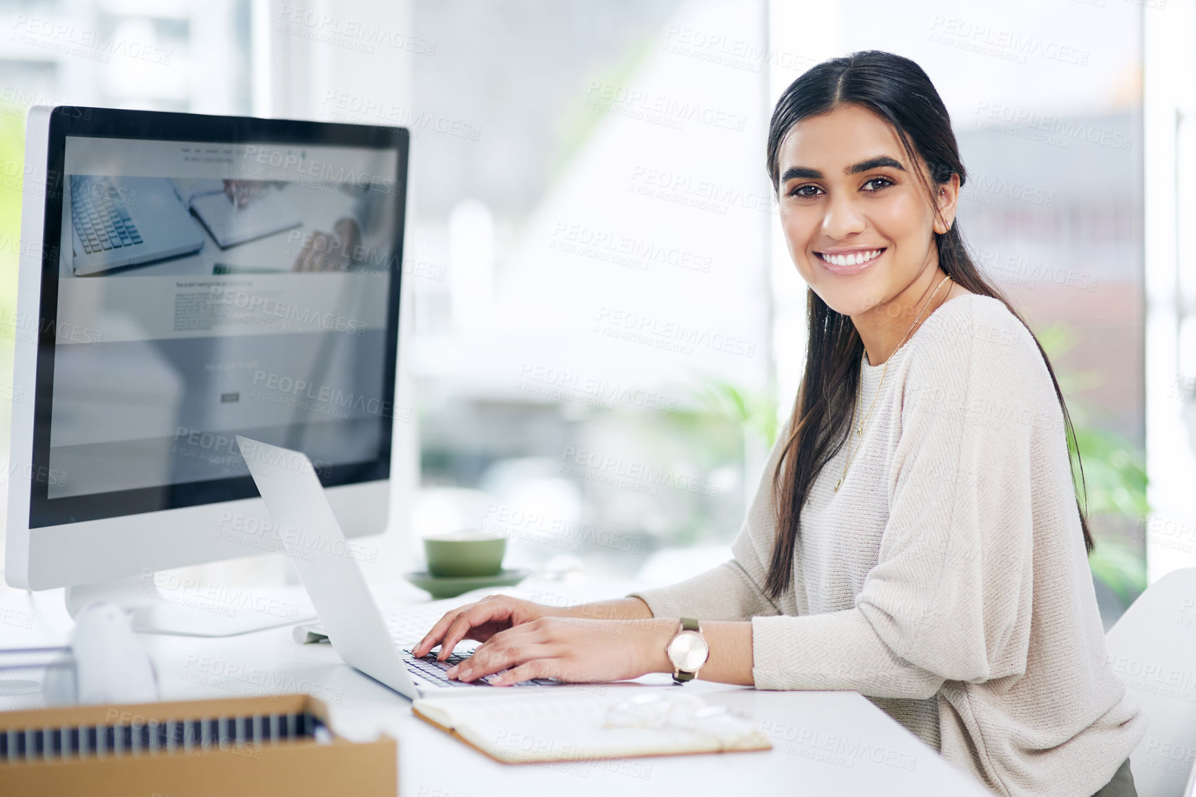 Buy stock photo Portrait of a young businesswoman working on a laptop in an office