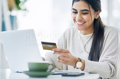 Buy stock photo Shot of a young businesswoman using a laptop and credit card in an office