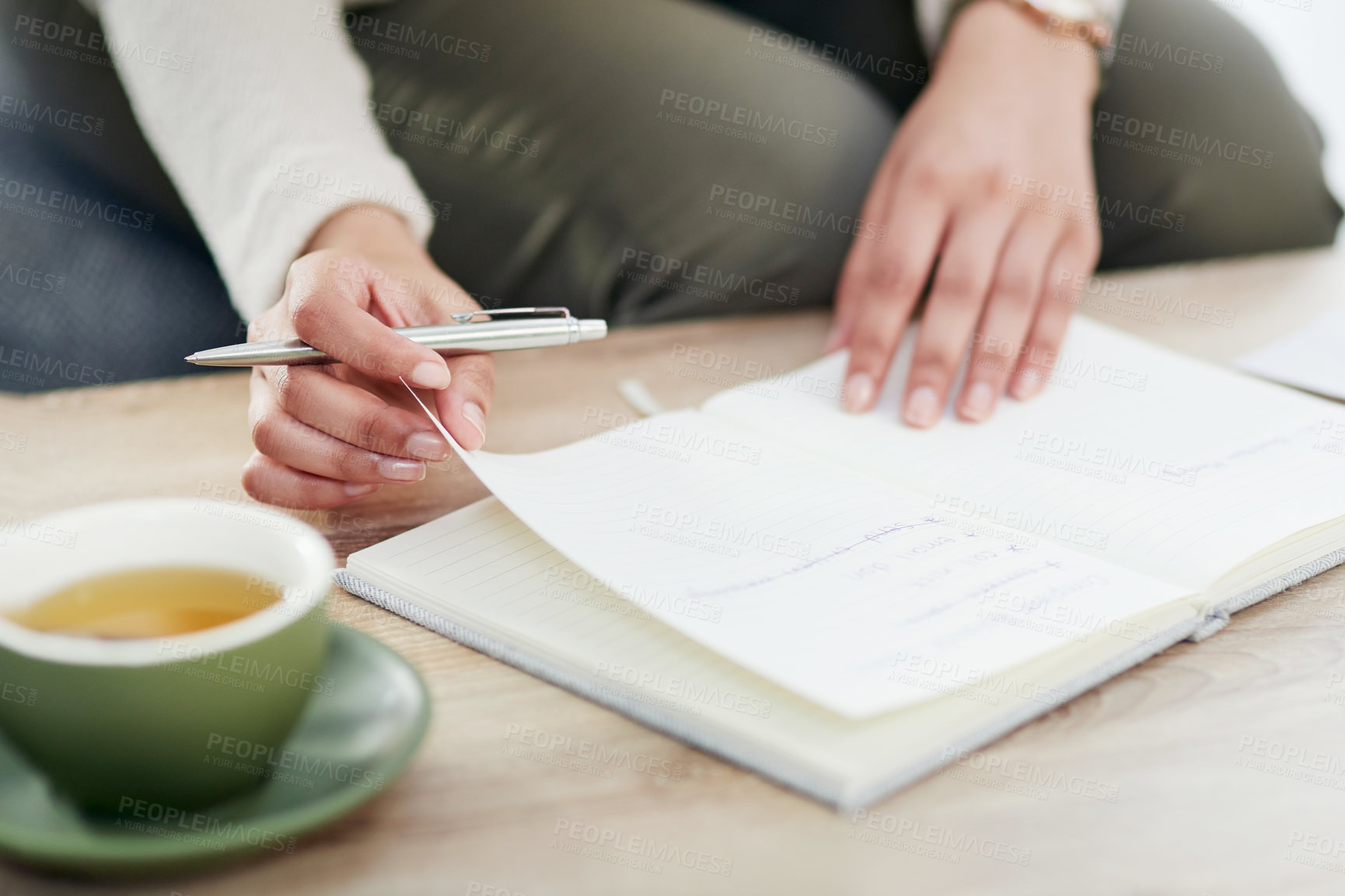 Buy stock photo Closeup shot of an unrecognisable businesswoman writing in a notebook in an office