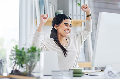 Buy stock photo Shot of a young businesswoman cheering while working on a computer in an office