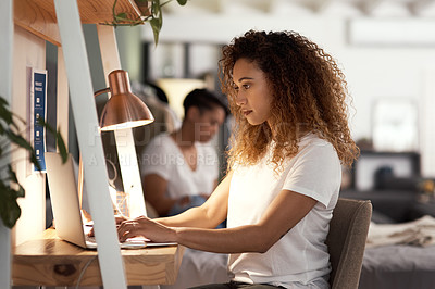 Buy stock photo Shot of a young woman using a laptop at in the lounge home