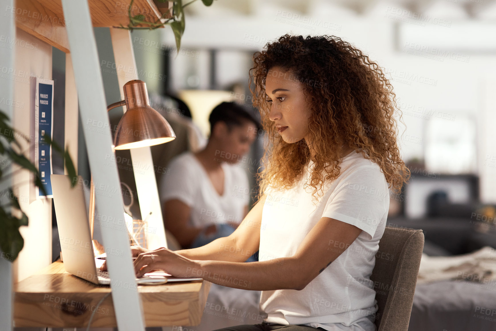 Buy stock photo Shot of a young woman using a laptop at in the lounge home