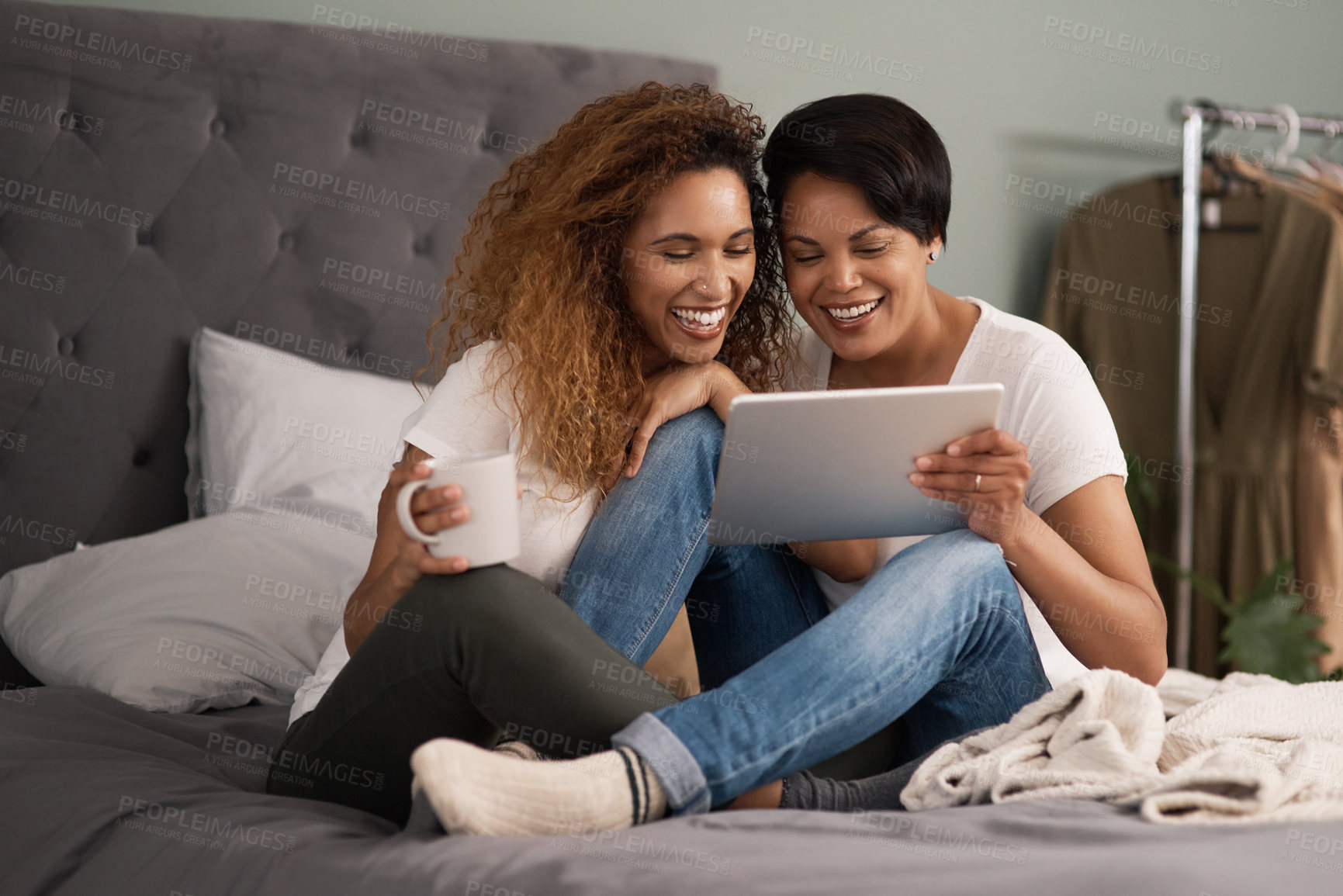 Buy stock photo Shot of a couple using a tablet while sitting on the bed at home