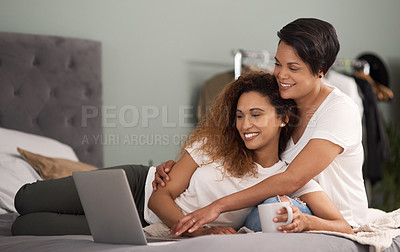 Buy stock photo Shot of a couple using a laptop while sitting on the bed at home