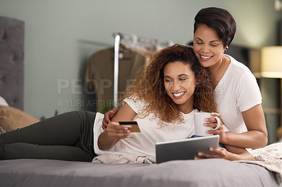 Buy stock photo Shot of a couple using a tablet while sitting on the bed at home