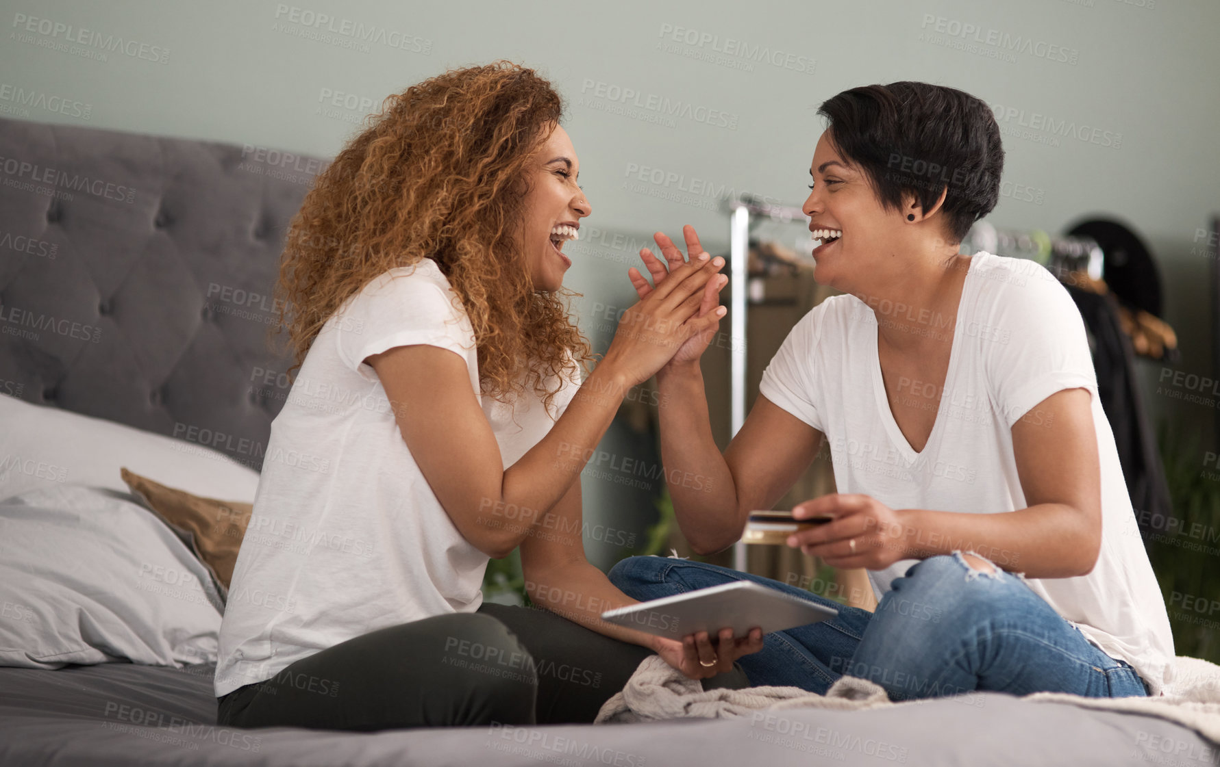 Buy stock photo Shot of a couple using a tablet while sitting on the bed at home