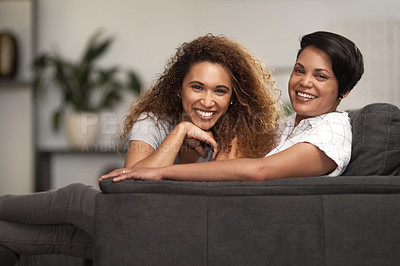 Buy stock photo Shot of a lesbian couple sitting on the couch at home