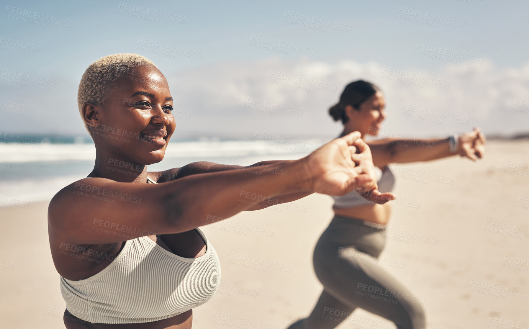 Buy stock photo Shot of two young women practicing yoga on the beach