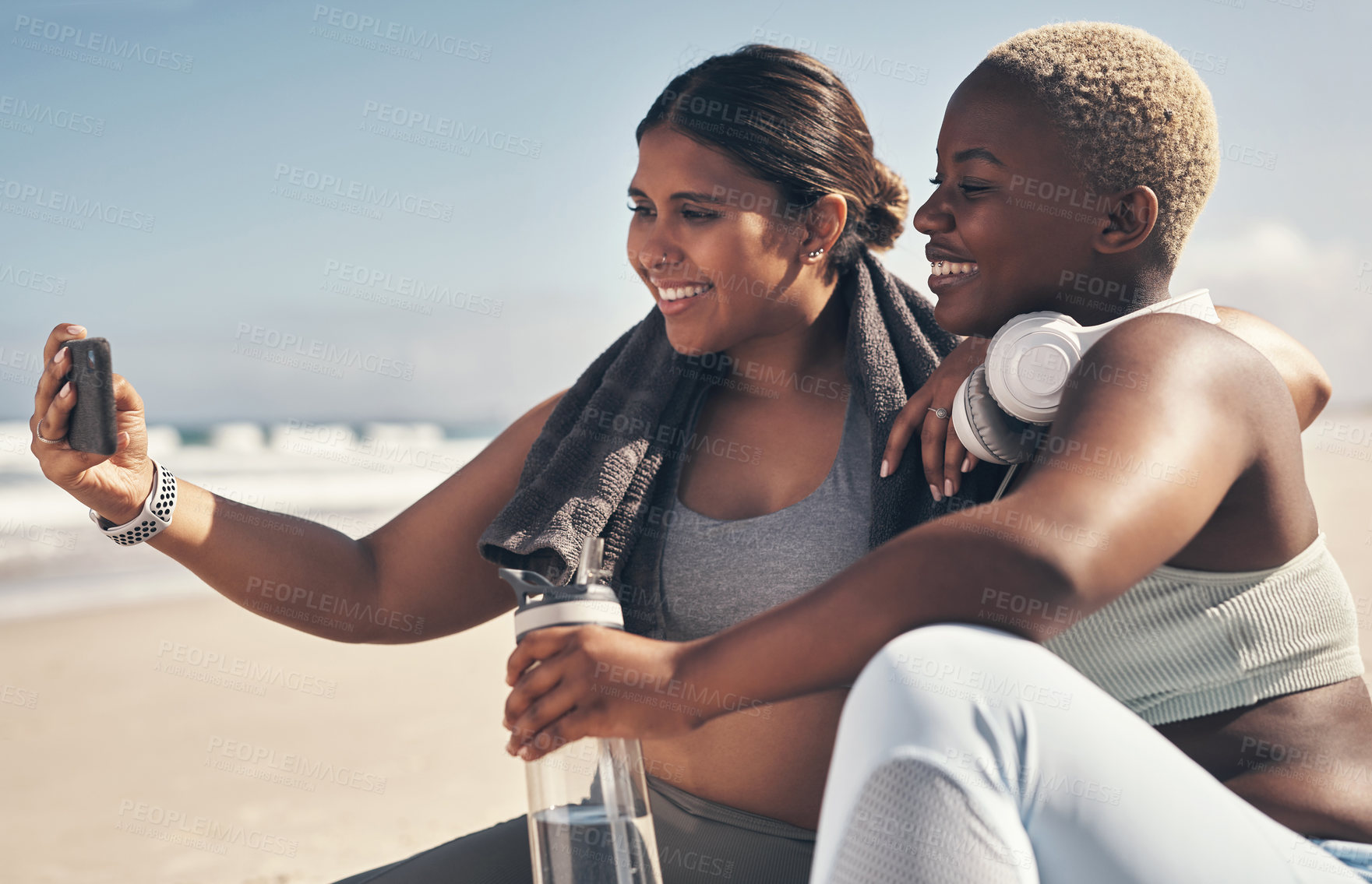 Buy stock photo Shot of two sporty young women taking a selfie while exercising at the beach