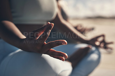 Buy stock photo Shot of a woman meditating during her yoga routine on the beach