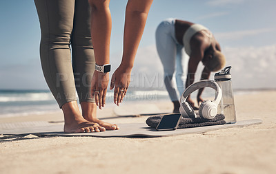 Buy stock photo Shot of two young women stretching on the beach