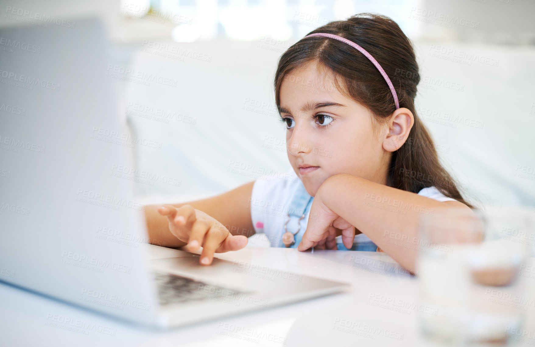 Buy stock photo Shot of a little girl using a laptop at home