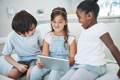 Buy stock photo Shot of a group of little children using a digital tablet at home