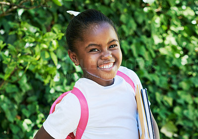 Buy stock photo Shot of a little girl wearing a backpack while carrying books in nature