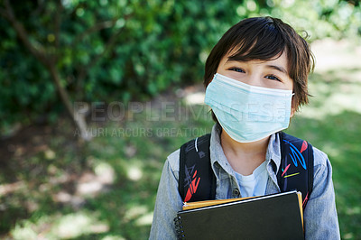 Buy stock photo Shot of a little boy wearing a backpack while carrying books in nature