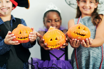 Buy stock photo Shot of a group of little children showing their carved pumpkins at a party