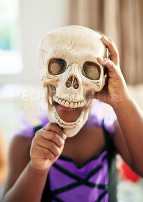 Buy stock photo Shot of an unrecognizable little child covering their face with a skull