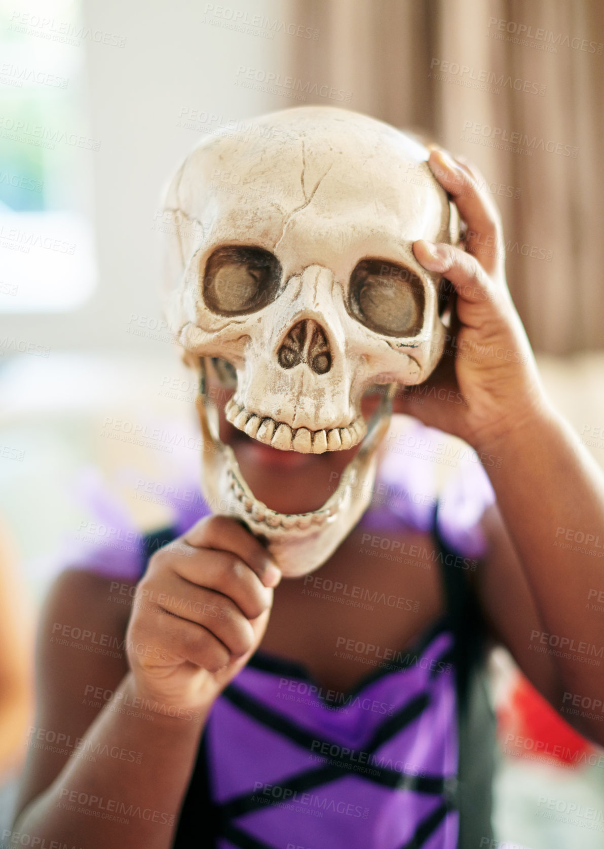 Buy stock photo Child, costume and skull for halloween in home, celebrate with props for holiday with scary theme. Girl, living room and skeleton for party event with kids, crazy clothes for development in USA