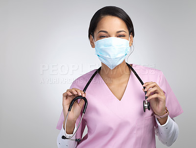 Buy stock photo Cropped portrait of an attractive young female healthcare worker wearing a mask and stethoscope while standing in studio against a grey background