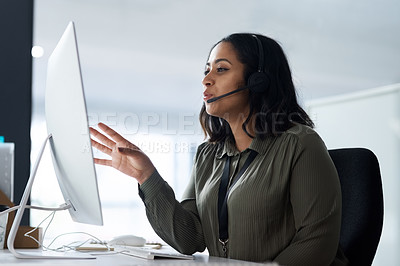 Buy stock photo Shot of a woman wearing a headset while looking at her desktop in a call centre