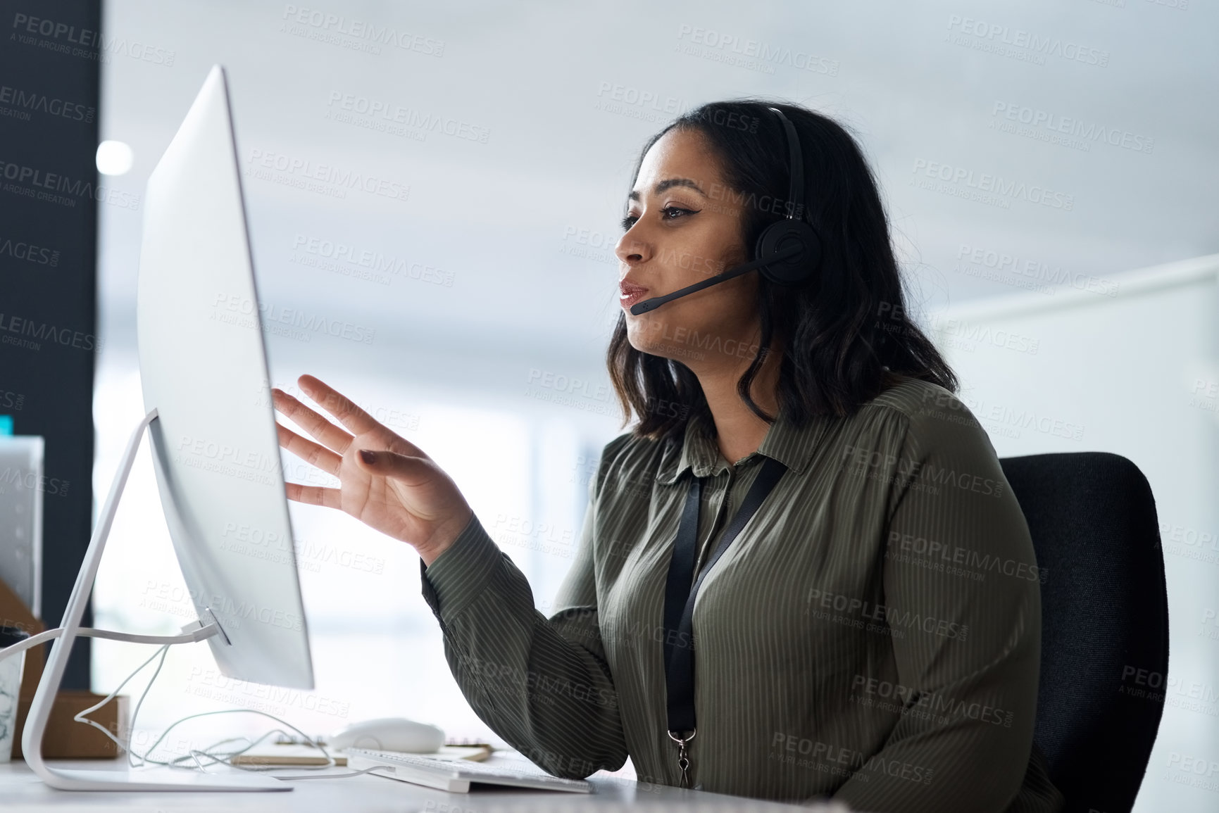 Buy stock photo Shot of a woman wearing a headset while looking at her desktop in a call centre