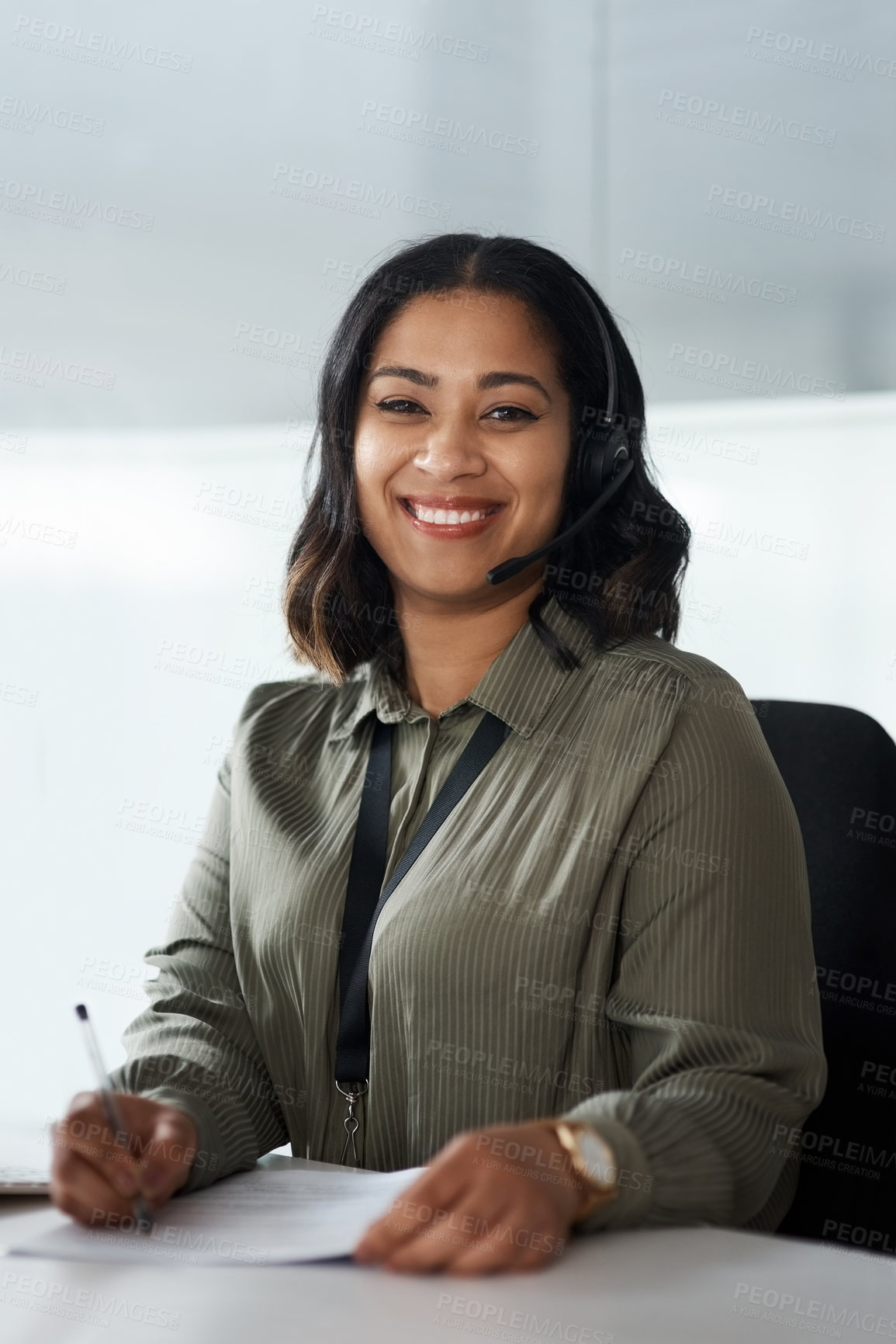 Buy stock photo Shot of a young businesswoman wearing a headset while working in a call centre