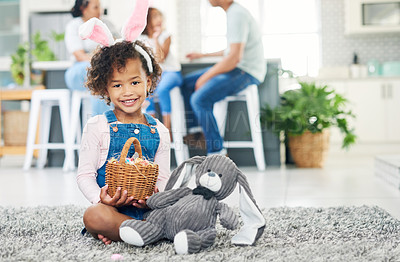 Buy stock photo Shot of a young girl sitting on the floor with easter eggs at home