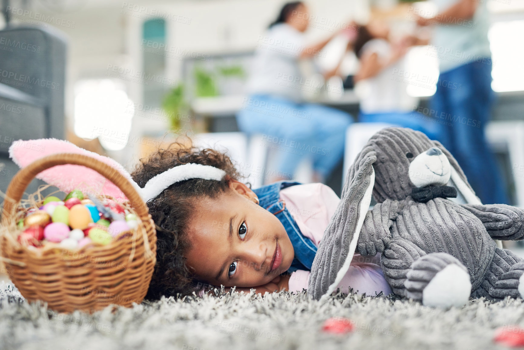 Buy stock photo Shot of a young girl sitting on the floor with easter eggs at home