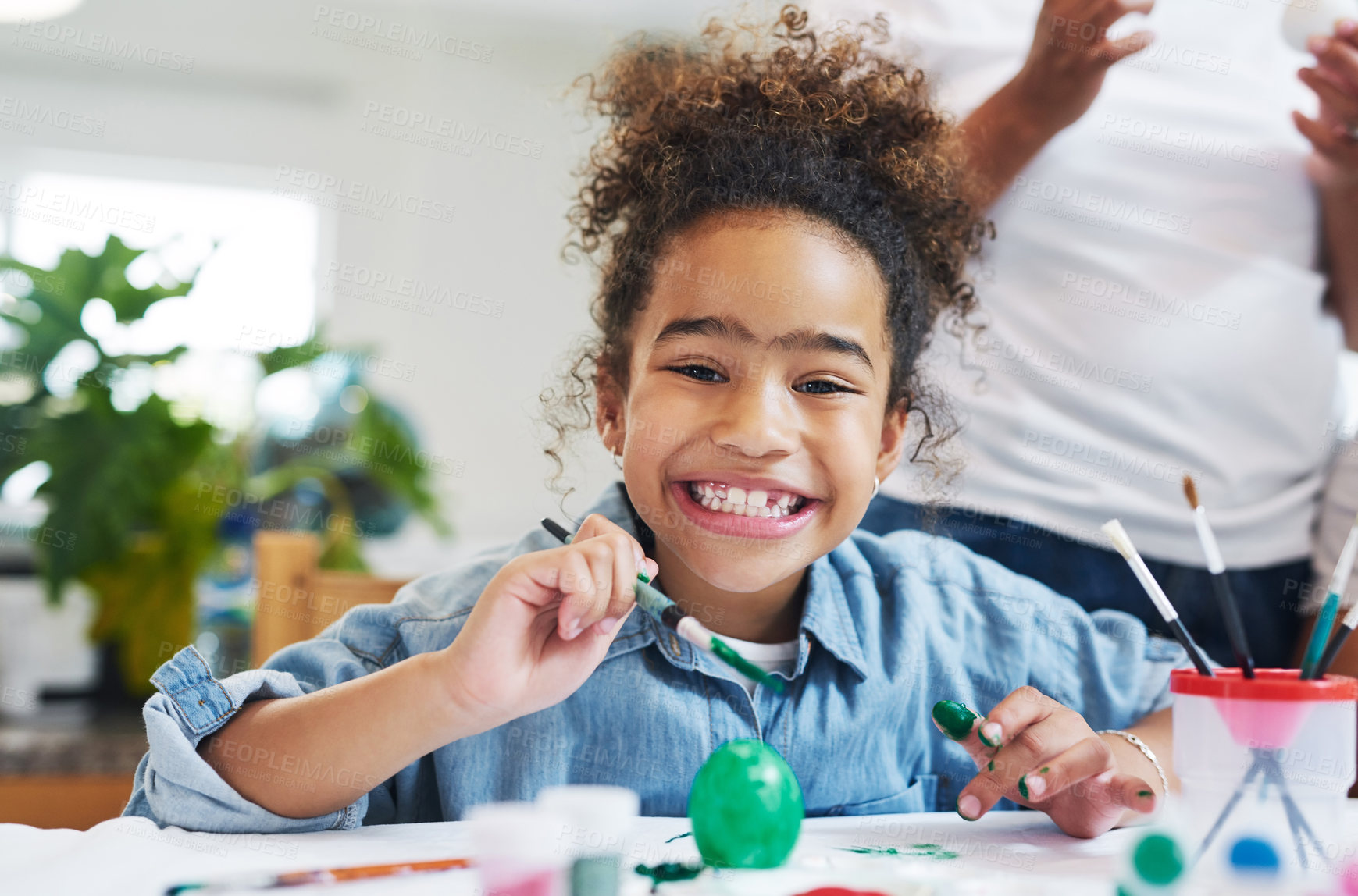 Buy stock photo Cropped shot of a young girl painting eggs at home