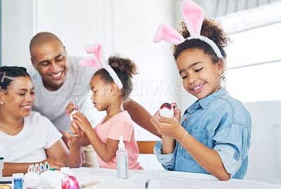 Buy stock photo Shot of a mother and father painting eggs with their daughter at home