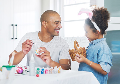 Buy stock photo Shot of a man painting eggs with his daughter at home