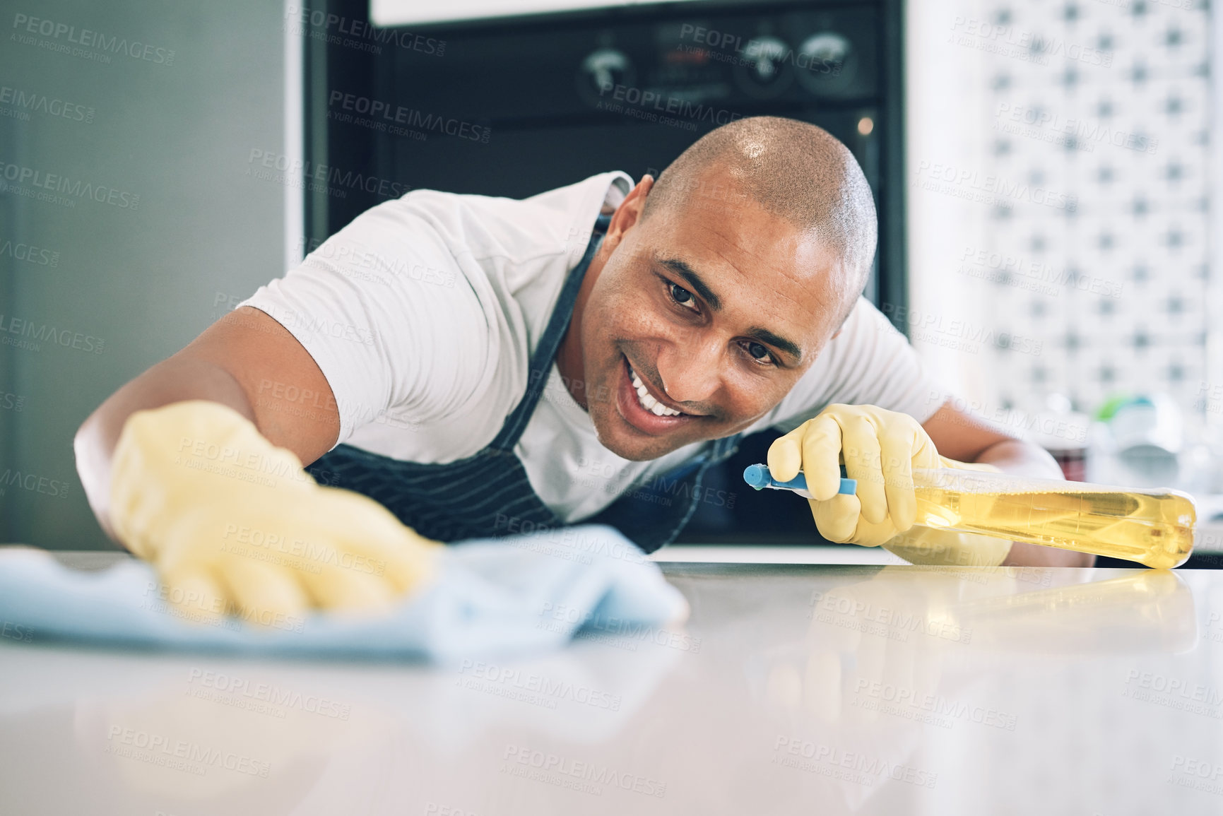 Buy stock photo Shot of a young man wiping a surface at home